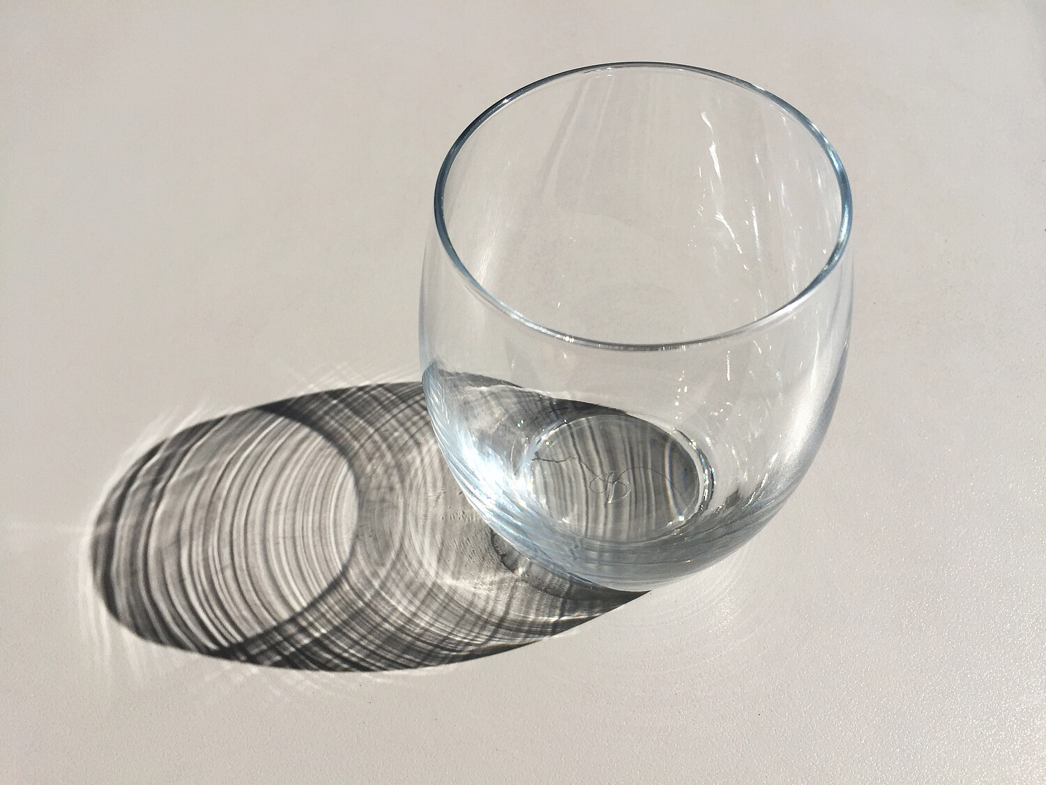 Empty glass with reflection on table surface