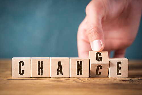 hand flipping one of six cubes, turning the word "change" to "chance"