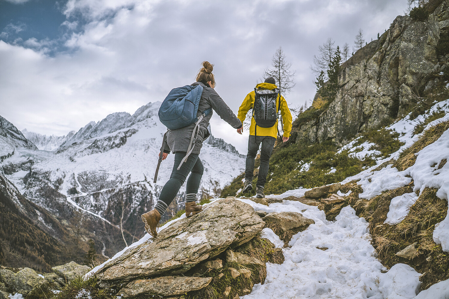 Young couple of hikers bound up ridge together